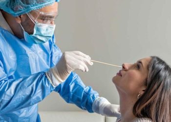 Un medico haciendo el test de covid a una paciente gsc1